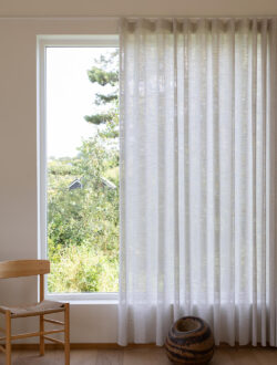 Luxaflex® transparente stofgardiner i hvid, der hænger i et stort vindue.
