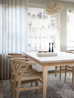 Hvide Luxaflex® stofgardiner, der hænger i en lys spisestue.